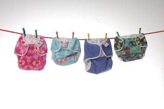Four reusable nappies hanging on a washing line